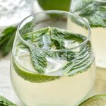 glass of mojito sangria cocktail with mint and limes