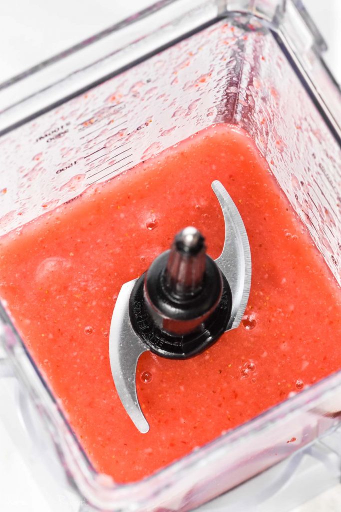 overhead of blender with strawberry wine slushies in it
