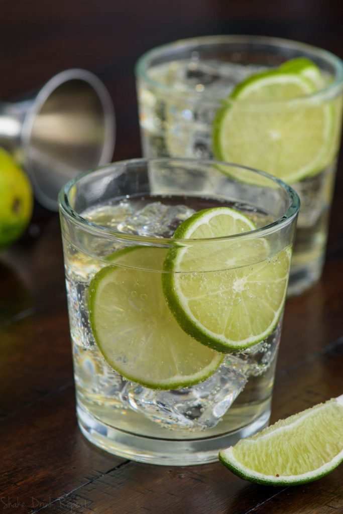 glass of the perfect gin and tonic with two lime slices