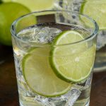 glass of the perfect gin and tonic with two lime slices