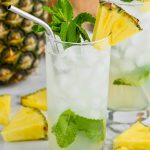 pineapple mojito in a tall glass garnished with mint and fresh pineapple