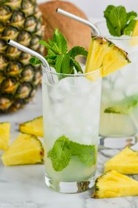 pineapple mojito in a tall glass garnished with mint and fresh pineapple