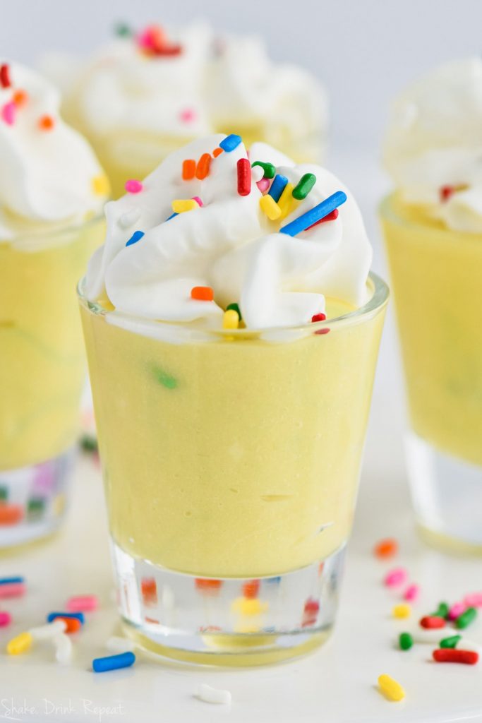 one birthday cake pudding shot with whipped cream and sprinkles