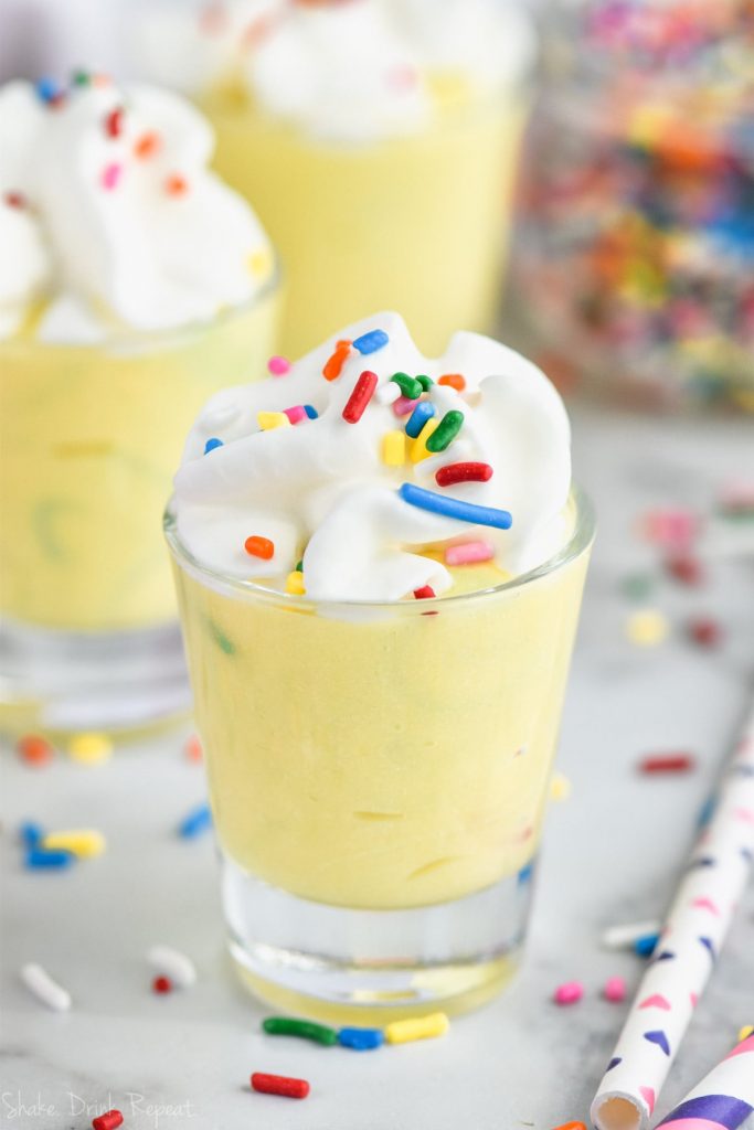 one birthday cake pudding shot with whipped cream and sprinkles