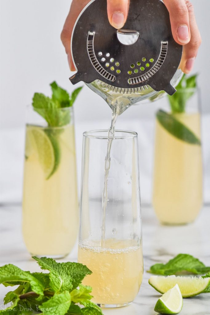 moscow mule being strained into a champagne glass