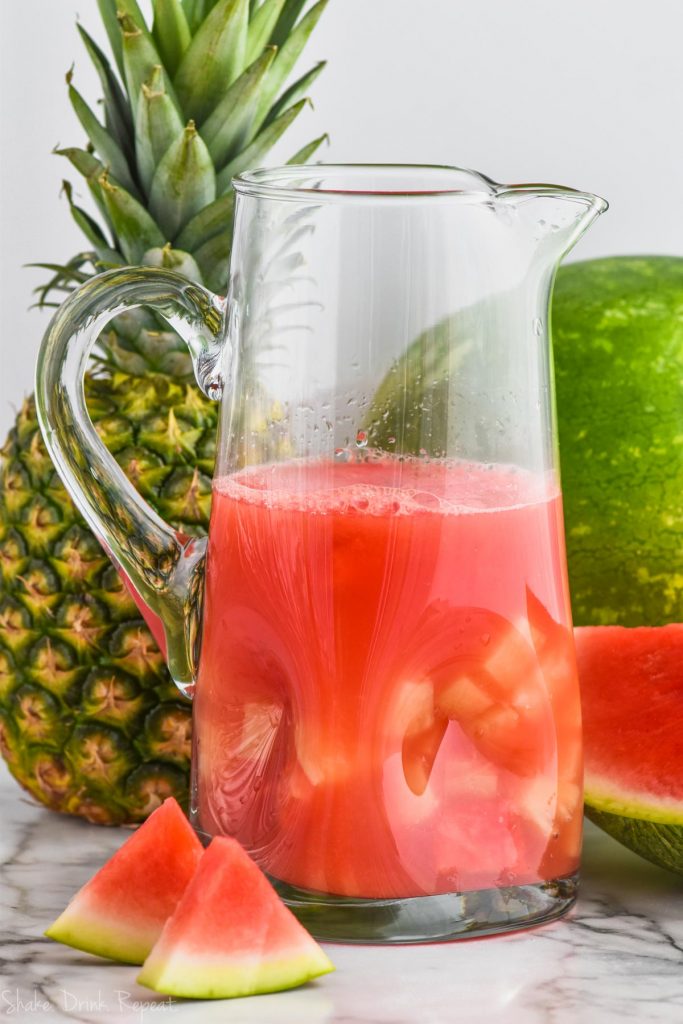 pitcher of watermelon rum punch cocktail with floating pineapple
