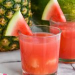 cup of rum punch recipe with floating pineapple and watermelon