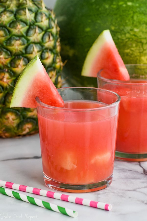 cup of rum punch recipe with floating pineapple and watermelon