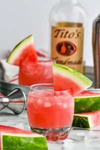 glass of watermelon vodka tonic garnished with a watermelon wedge