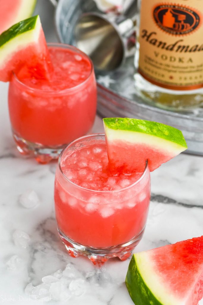 glass of watermelon vodka tonic garnished with a watermelon wedge
