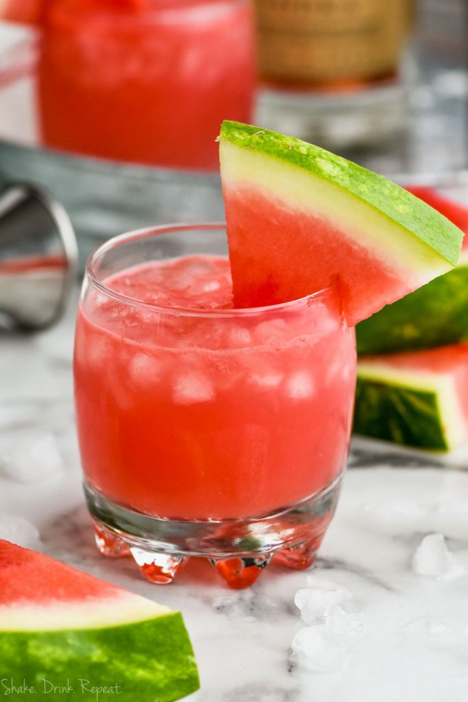 glass of watermelon vodka tonic garnished with a watermelon wedge