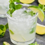 a mojito margarita in a salt rimmed glass with fresh mint and a lime wedge