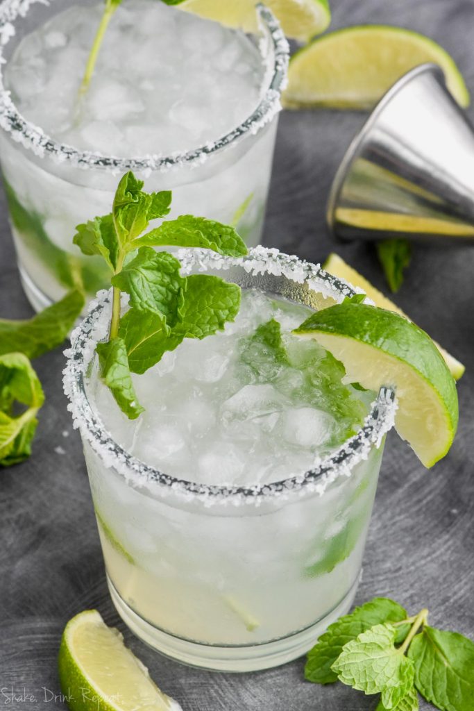 a mojito margarita in a salt rimmed glass with fresh mint and a lime wedge