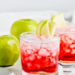 cranberry apple whiskey cocktail garnished with apple