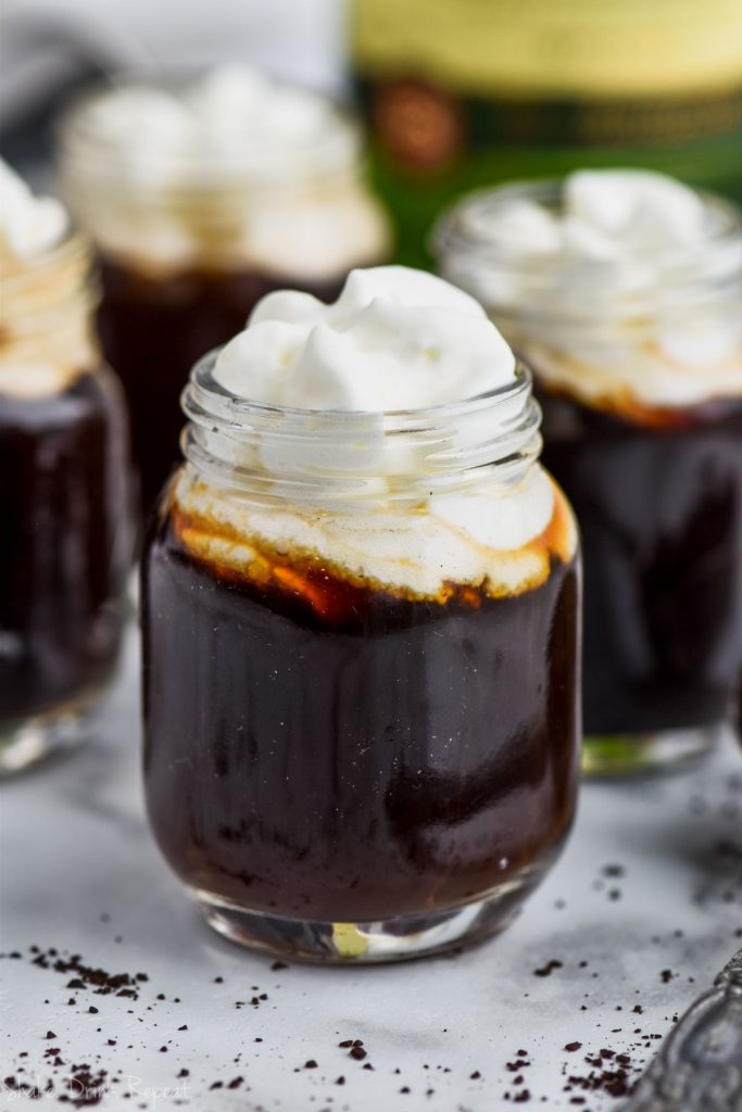 close up of irish coffee shot topped with whipped cream