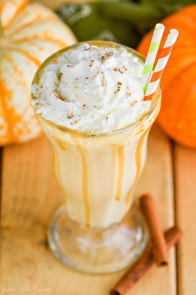 boozy pumpkin milkshake with whipped cream and straws