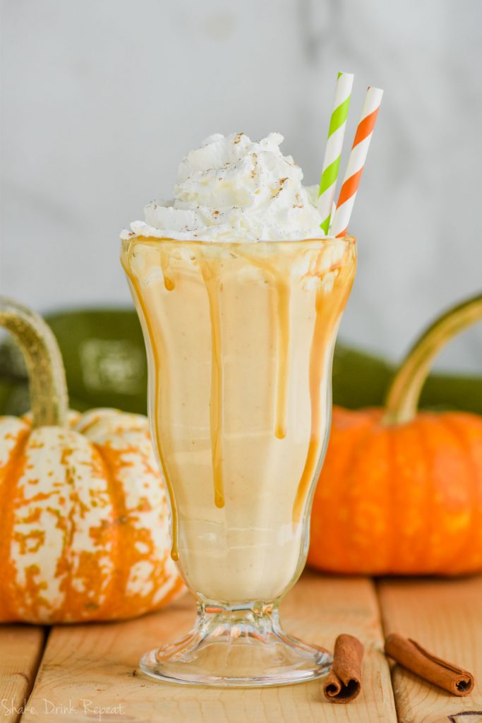 boozy pumpkin milkshake with whipped cream and straws