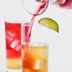Bay Breeze in a glasses with lime slices and ice and drink being poured into them