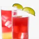 Pinterest graphic for Bay Breeze cocktail. Text says "the best bay breeze only uses 3 simple ingredients shakedrinkrepeat.com" Image shows two glasses of bay breeze cocktails with lime wedges.