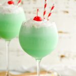 Drink in Tall Glass with straws, cherries and whip cream