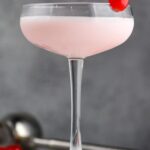 Pink lady drink in a glass with a cherry