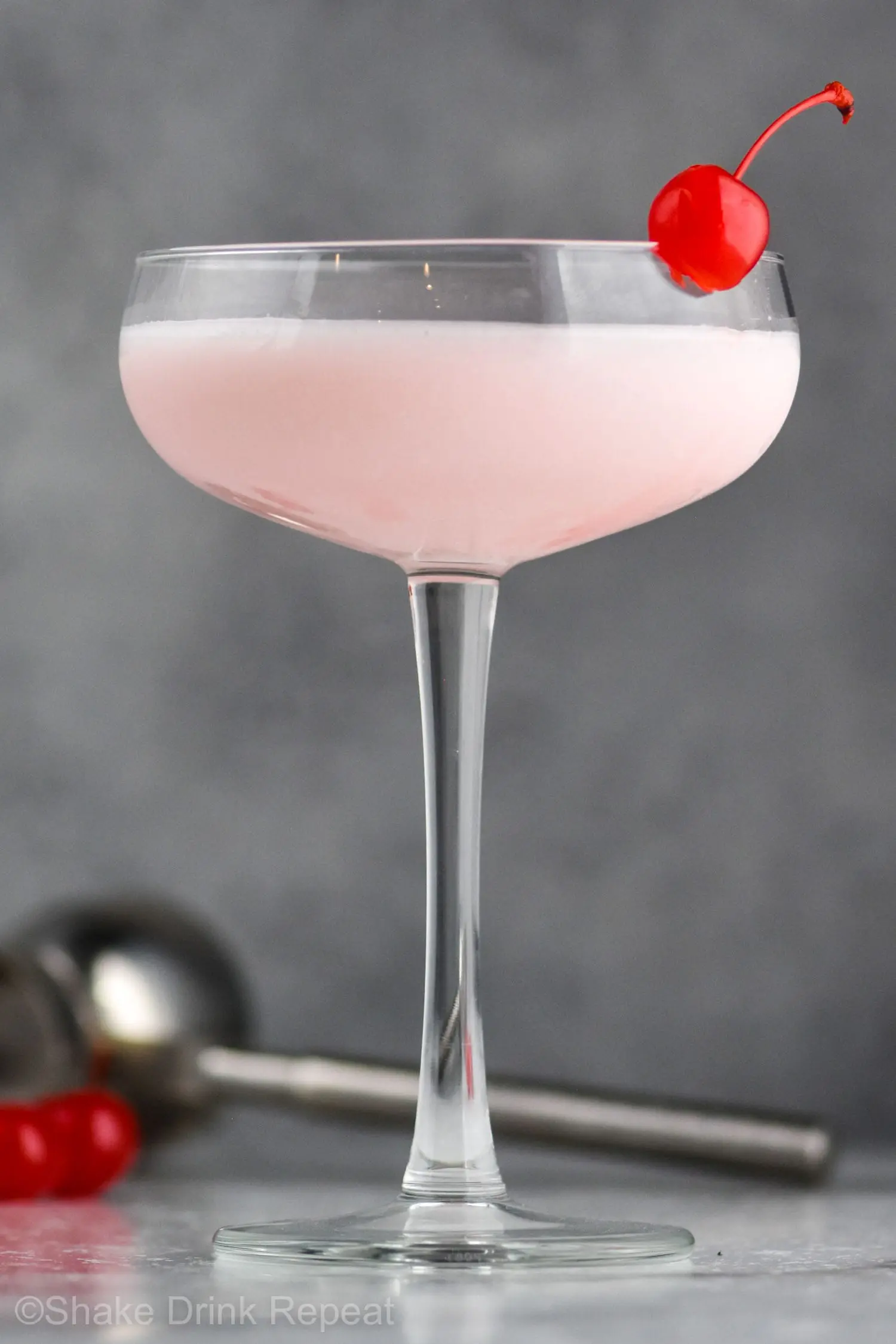 Pink lady drink in a glass with a cherry