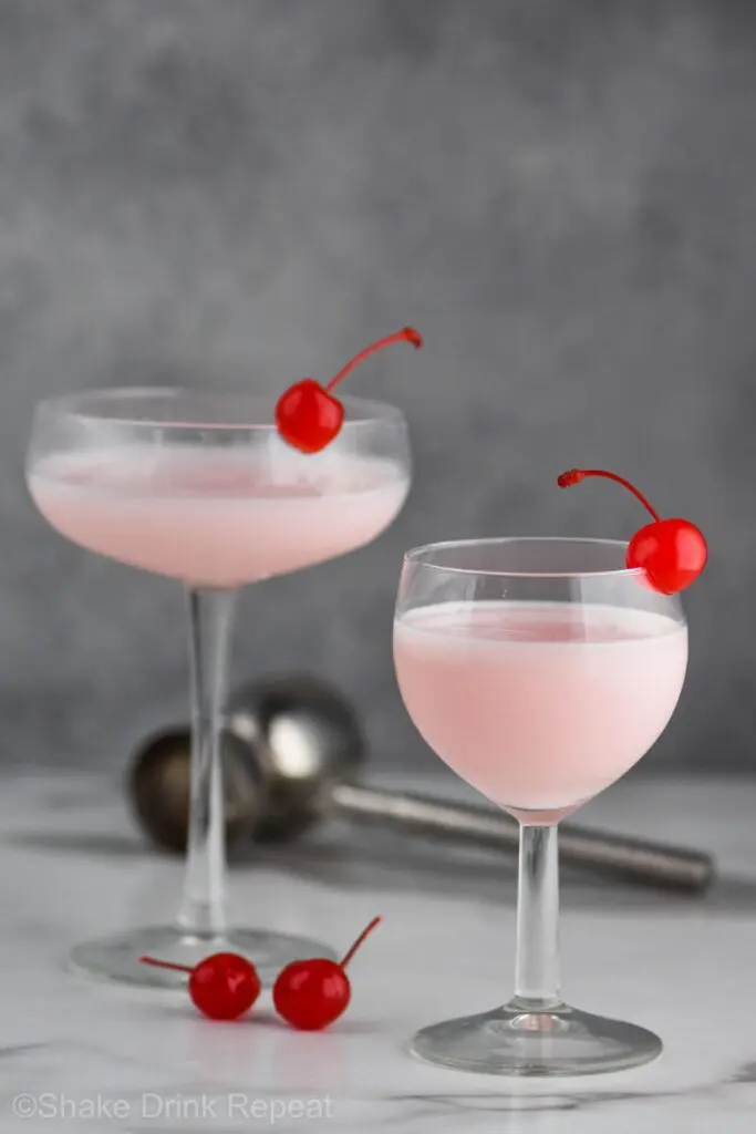 Two pick lady drink in glasses with cherries in the glasses and in the picture