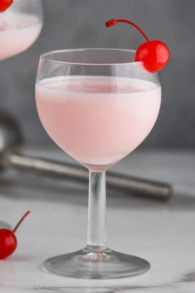 Pink lady cocktail  in glass with a cherry