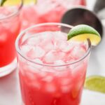 Sea Breeze Drink in a tumbler with ice and lime wedge