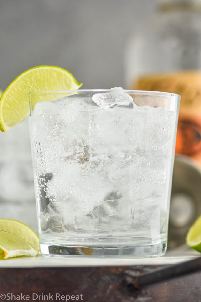 Glass of Vodka Soda with ice and lime wedges