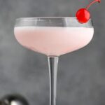 Pink lady drink in glass with a cherry