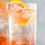 glass of americano cocktail with ice and orange slice garnish