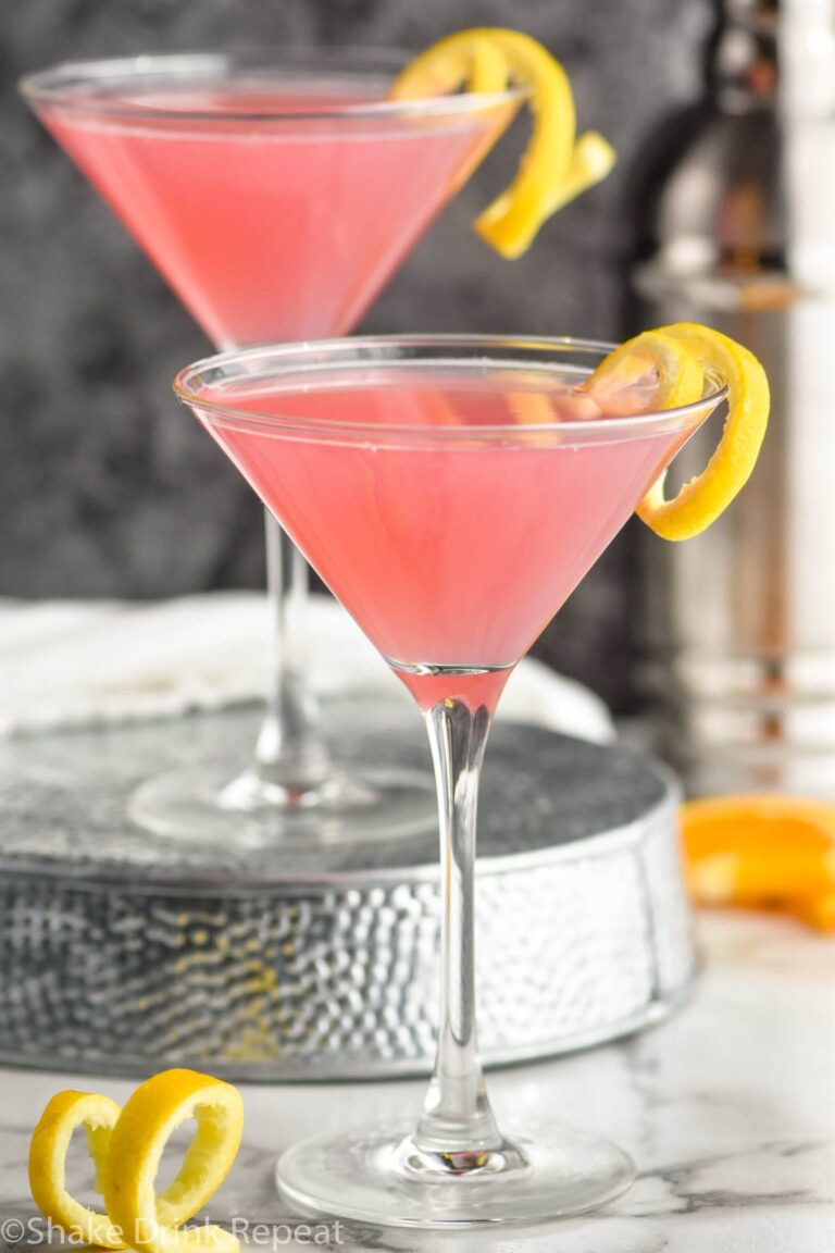 Two Cosmopolitan Cocktail's in a glass garnished with a lemon twist