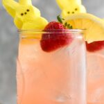 Drunk Bunny Cocktail in glass with ice, peep, lemon wedge and strawberry.