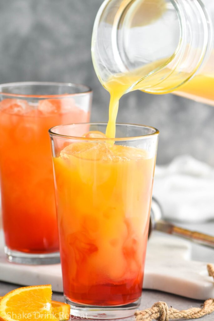 two glasses of garibaldi cocktail with ice and orange juice