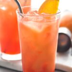 two glasses of Garibaldi cocktails with ice, straws and orange garnish