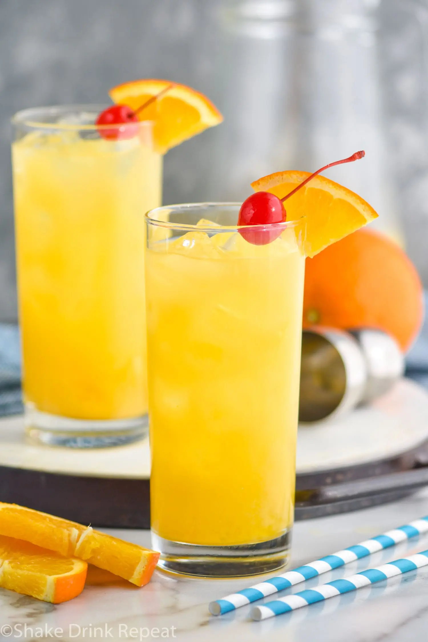 two glasses Harvey Wallbanger drink with orange wedge and cherry garnish