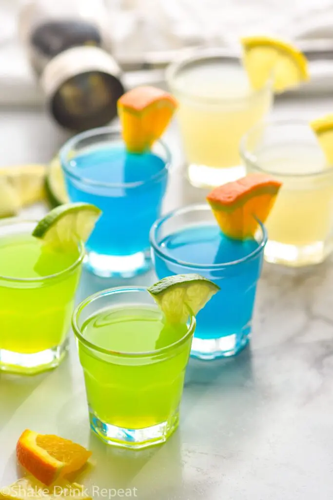 shot glass with green and blue kamikaze shot with orange and lime wedge