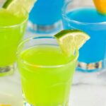 4 kamikaze shots in glasses with lime and orange wedge garnish