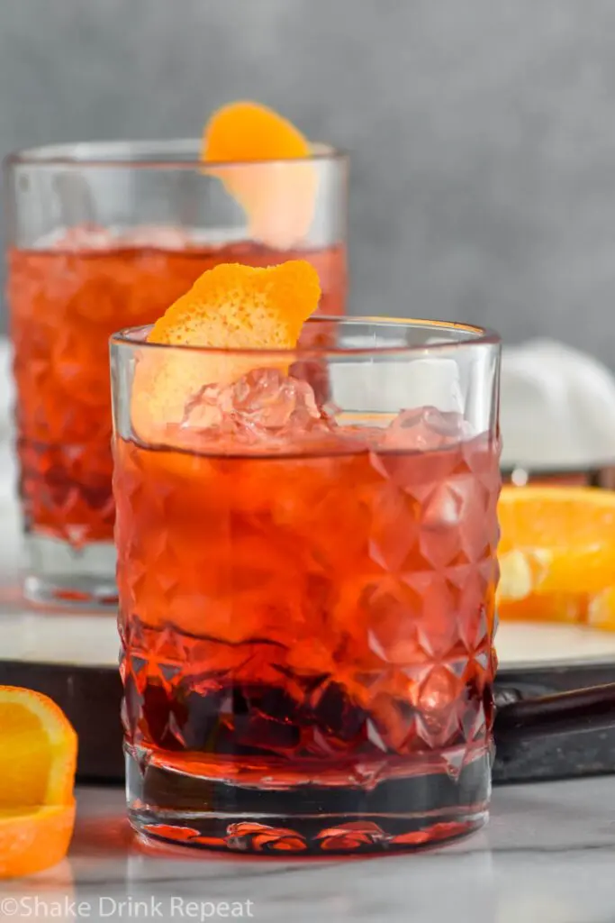 two glasses of Negroni with ice and orange twist