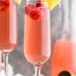 champagne flutes pink mimosa with lemon and raspberries