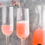 two glasses pink mimosa recipe with raspberries, lemonade and rose