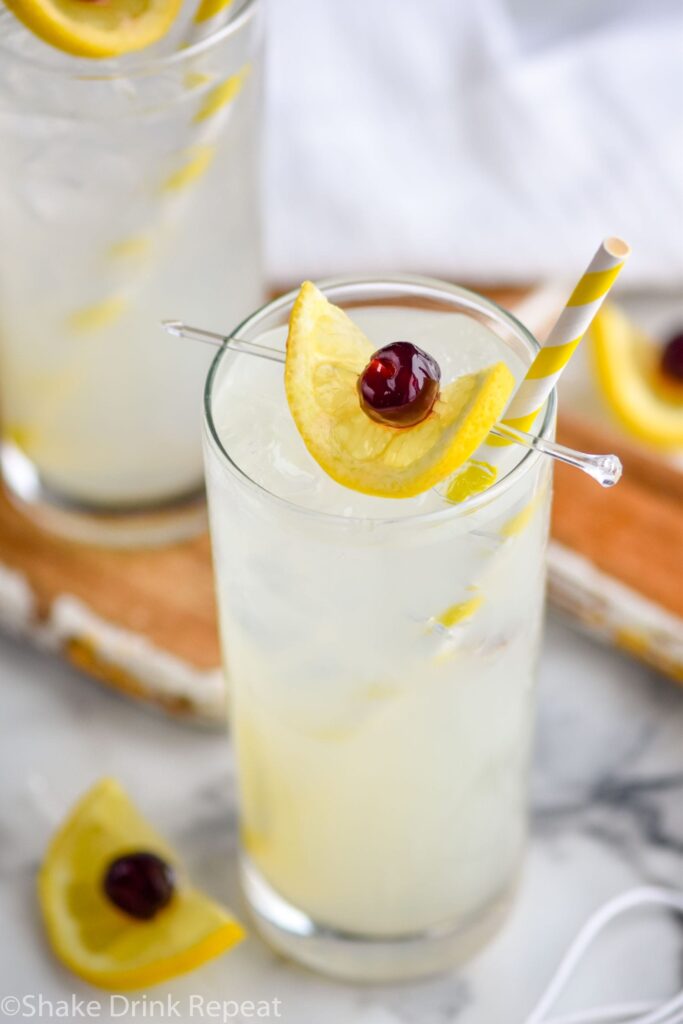 two glasses of tom collins with ice, lemon, cherry