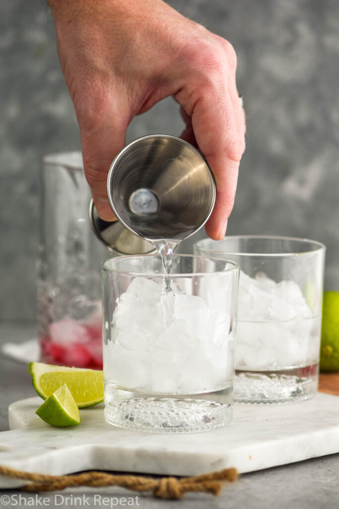 making vodka cranberry recipe with ingredients in background