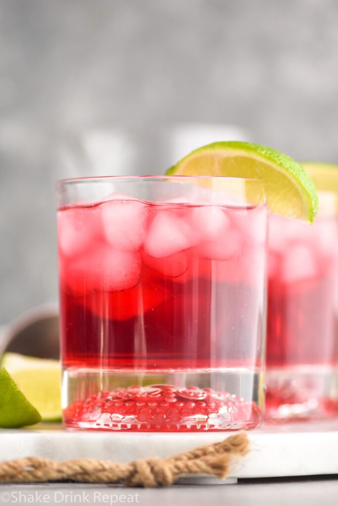 Glass of Vodka Cranberry recipe with ice and lime wedge