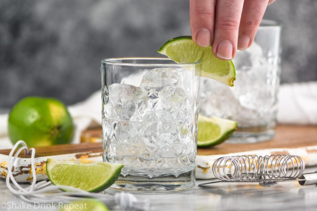 glass of Vodka tonic cocktail with ice and lime wedge