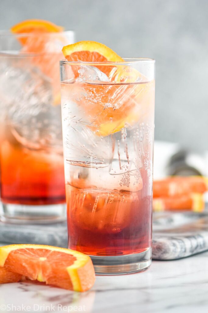 two glasses of americano cocktail with ice and orange slice garnish