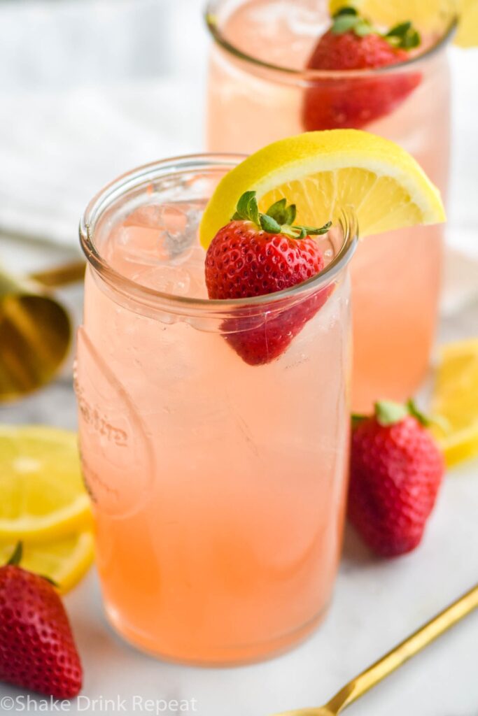 Drunk Bunny Cocktail in glass with ice, lemon wedge and strawberry.