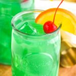 Two glasses of Drunk Leprechaun with orange and cherry garnish