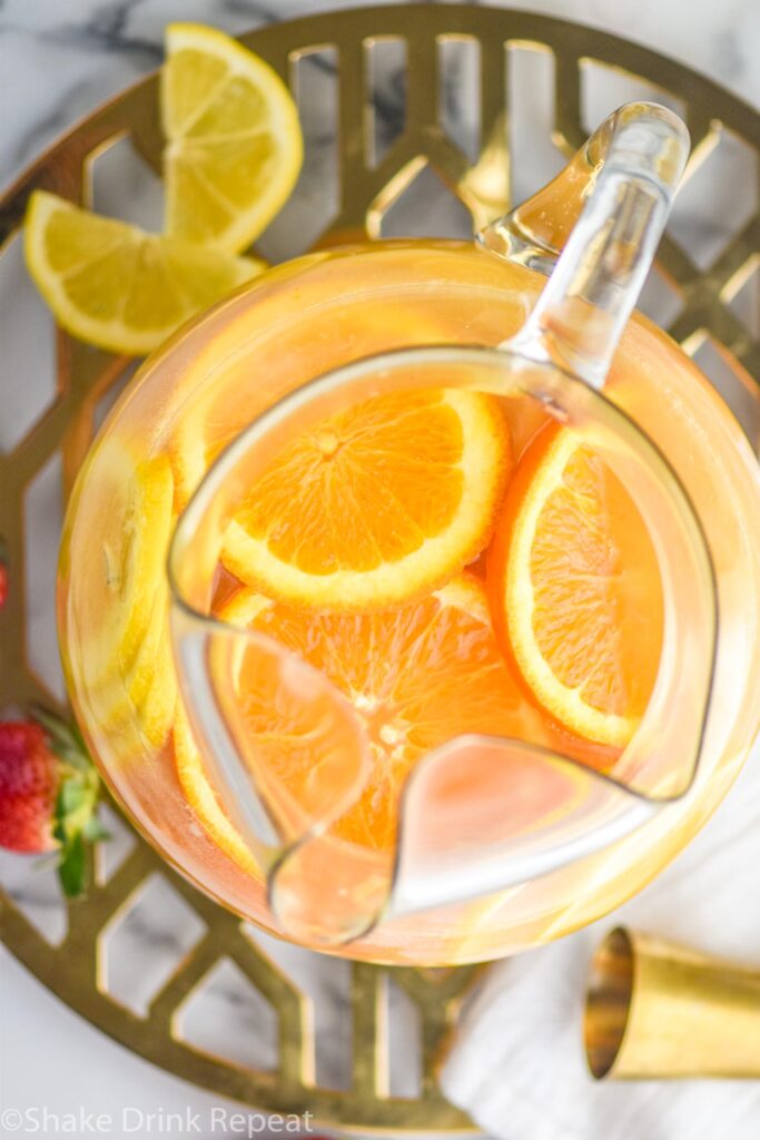 pitcher of mimosa sangria recipe with orange slices and strawberry